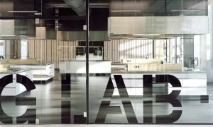 Hoge glazen systeemwand met belettering