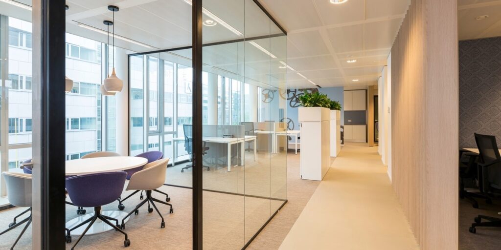 Moderne vergaderruimte met glazen wanden in een kantooromgeving.