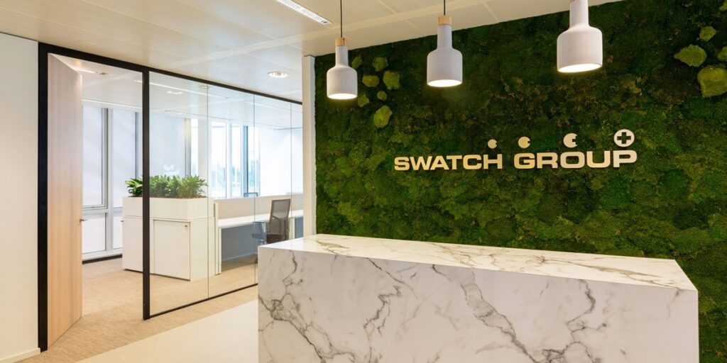 Receptie van de Swatch Group met moswand en marmeren balie.