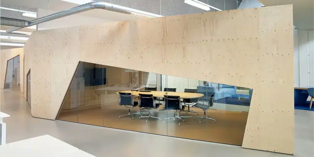 Moderne vergaderruimte met houten wanden en glazen ramen in een kantoor.