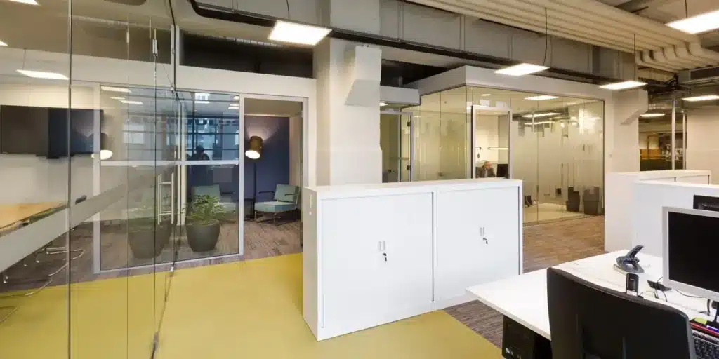 Modern kantoorinterieur met glazen wanden en open werkplekken.