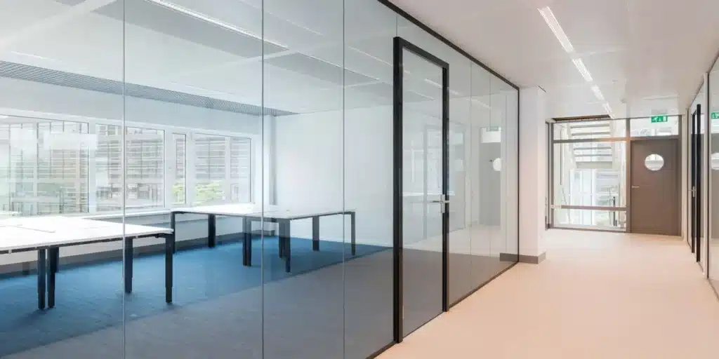 Kantoor interieur met glazen wanden en tafels.