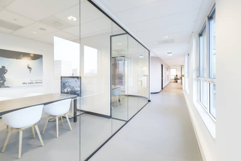 Modern kantoorinterieur met transparante glazen kantoorwanden en witte stoelen